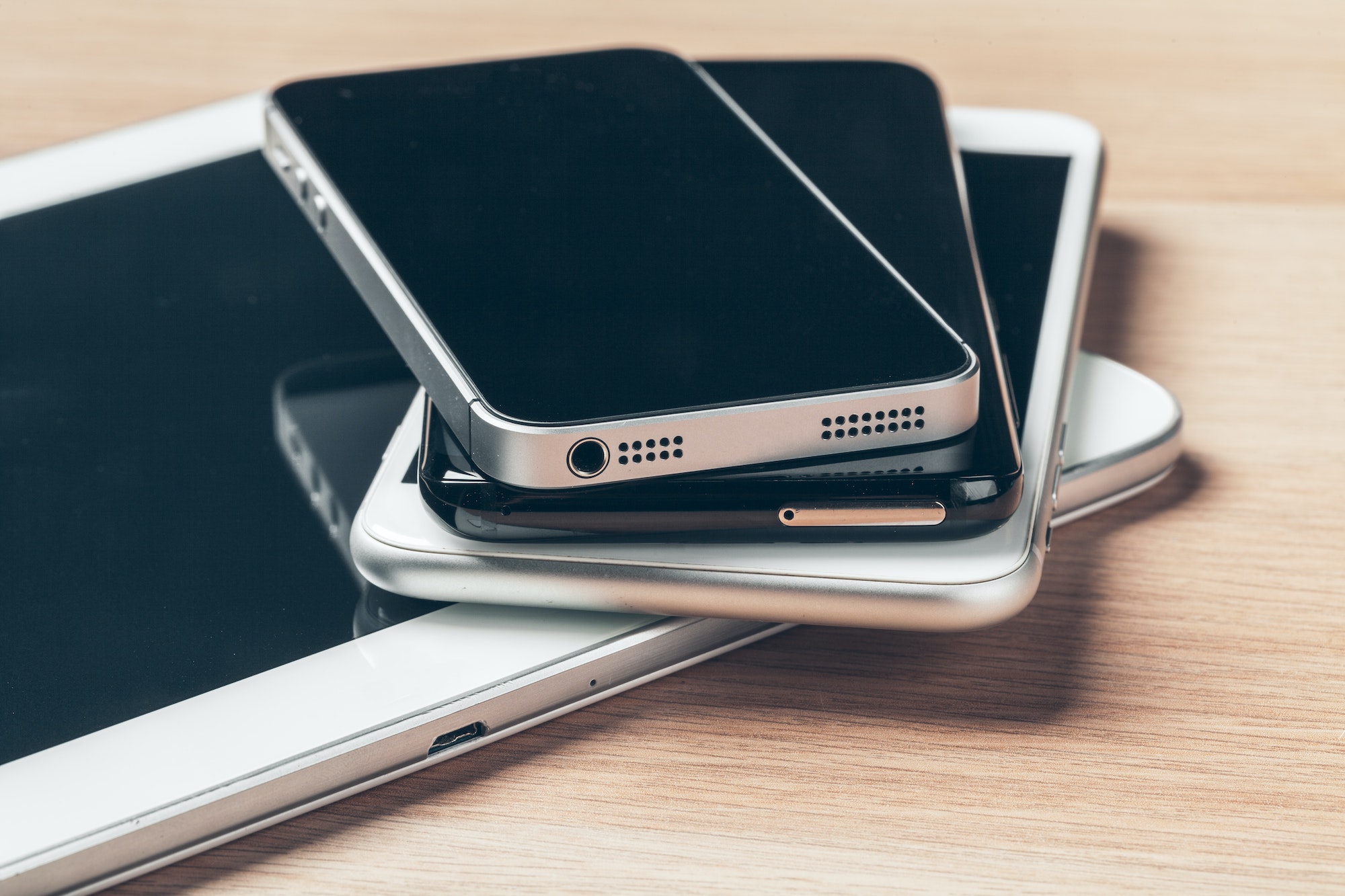 Digital tablet and mobile phone. Electronic devices on wooden table, close up